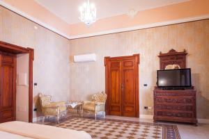 Televízia a/alebo spoločenská miestnosť v ubytovaní Palazzo Montalbano