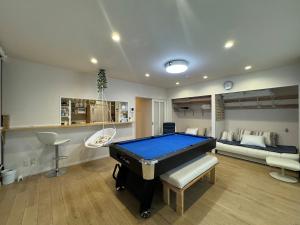 冈山Lhouseー遊べる宿ビリヤード 大型スクリーン 岡山駅徒歩15分的客厅里有一张台球桌和一张沙发。