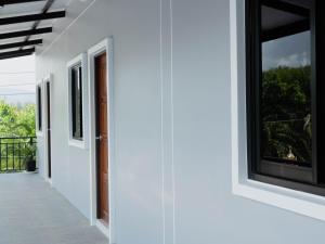 a white house with windows and a balcony at Borrii House โบ ลี่ เฮาท์ in Layan Beach