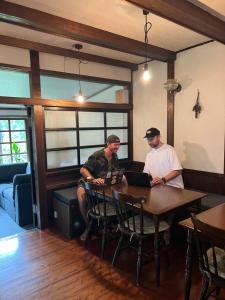 two men sitting at a table with a laptop at Twin Peaks Lodge in Hakuba +39 photos