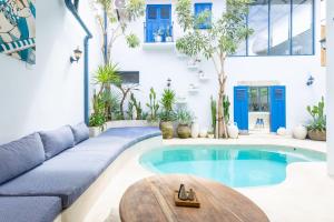 a living room with a pool and a couch and a table at Santorini Suites Canggu in Canggu