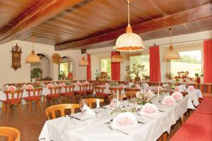 una sala banchetti con tavoli e sedie bianchi con tovaglioli rosa di Hotel Stockerwirt a Ramsau am Dachstein