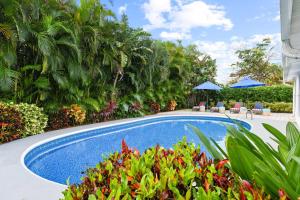 a swimming pool in a garden with plants and trees at 4br Home W Guest Suite Pool Near Pga & Beach in Palm Beach Gardens