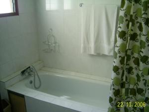 a bathroom with a bath tub with a shower curtain at Sampson's Guesthouse Company Ltd. in Kwashieman