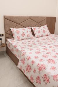 a bed with pink and white sheets and pillows at Hotel Janki Nandan Palace in Vrindāvan