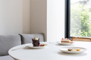 a white table with two plates of desserts on it at BON Osaka Namba East in Osaka