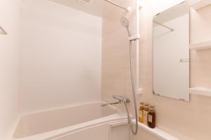 a shower in a bathroom with a mirror at BON Osaka Namba East in Osaka