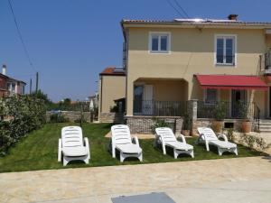 a group of lounge chairs in the yard of a house at Villa Ester in Umag