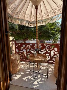 a patio with a table and an umbrella at Marilu's port mansion house in Gaios