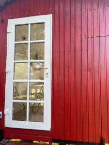 a red building with a white window on it at Bauwagen in Fanø