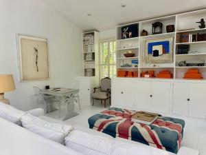 un soggiorno con un divano e un tavolo di Hibiscus Hill Cricket Pavilion - retreat near Pink Sand Beach cottage a Harbour Island Altre 16 foto
