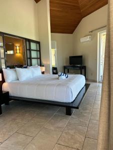 a bedroom with a large bed and a television at Sky Beach Club Bungalow 3 Steps from Beach With Club, Pool bungalow in Colebrooke Dale