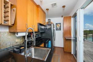 a kitchen with a sink and a black refrigerator at Touch of Class Estate - A Caribbean Beachfront Estate estate in Savannah Sound