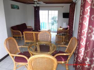 a dining room with a glass table and wicker chairs at On the Dune - Beachfront Cottage with 50 Mile Ocean View, Pool villa in Palmetto Point