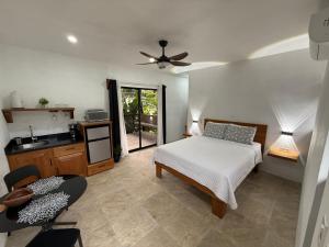 a bedroom with a bed and a kitchen with a ceiling fan at Creekside Lofts #1 in Fortuna