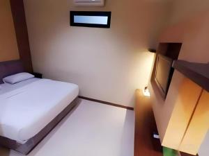 une petite chambre avec un lit blanc et une armoire dans l'établissement Hotel Khalista, à Gurungsang 105 autres photos