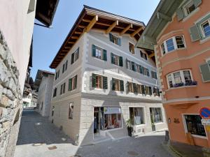 een wit gebouw met groene luiken op een straat bij Jägerhaus Apartment near ski area in Hopfgarten im Brixental