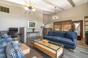 a living room with a blue couch and a table at The Inn at Gran View Ogdensburg, an Ascend Collection Hotel in Ogdensburg
