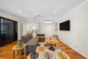 a living room with a couch and a table at Mountaintop Pool Retreat - The Ideal Family Escape in Buderim +40 photos