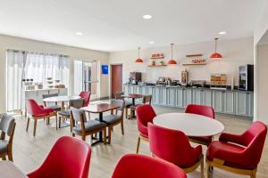 a restaurant with red chairs and tables and a counter at Comfort Inn Emporia in Emporia
