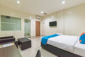 a bedroom with a bed and a flat screen tv at Sans Vibes Hotel Malabar in Bandung
