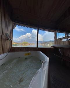 a bath tub with a view of the water at Luxury freedom group of houseboats in Srinagar