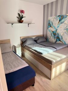 a bedroom with two beds and a plant on the wall at Platinum Guesthouse in Szeged