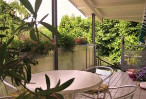 eine Terrasse mit Tisch und Stühlen und Blumen in der Unterkunft Zum Rebberg Ferienwohnungen in Freiburg im Breisgau