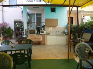 a living room with tables and chairs and a kitchen at Guest house Stoyanovi in Chernomorets