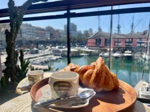 Una mesa con un plato de pasteles y una taza de café. en HFA Morosini by the Sea parcheggio incluso, en Génova