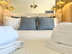 Un dormitorio con una cama con almohadas azules y blancas. en HFA Morosini by the Sea parcheggio incluso, en Génova