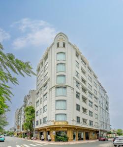 a large white building on a city street at Seven Stars Hotel & Apartment in Vung Tau