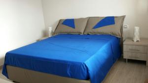 a blue bed in a bedroom with a night stand at Marea Sicula in Siracusa
