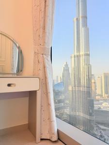 a bathroom with a window with a view of a skyscraper at Grande Downtown Dubai Luxury 2BR Apt with Burj Khalifa & Dubai Fountain Views in Dubai