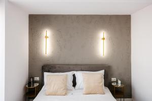 a bedroom with a bed with two lamps on the wall at Premium Tulip Apartments in Tunari