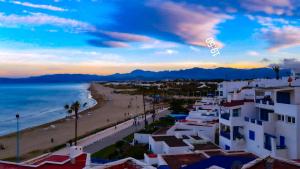 a view of a beach with buildings and the ocean at Maison Duplex pied dans l'eau in Cabo Negro +17 photos