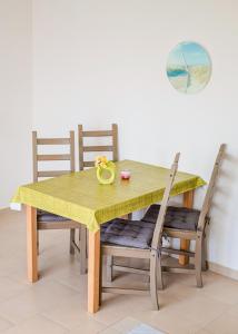 a dining room table with a yellow tablecloth and chairs at Ferienhaus "Steffi" in Rerik