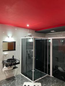 a bathroom with a glass shower and a sink at Agha Motel in Canela +24 photos
