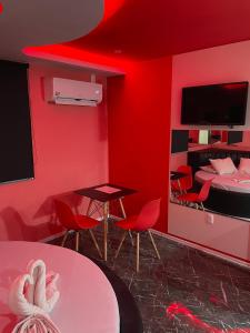 a red room with a bed and a table and chairs at Agha Motel in Canela