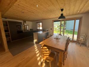 a kitchen and dining room with a large wooden table at Chalet PIERRA MENTA ski & commodités in Taninges