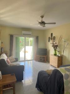 a living room with a couch and a tv at Pelagos Hill Apartment in Paphos