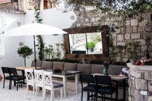 a patio with a table and chairs and an umbrella at Sakula Hotel in Alaçatı