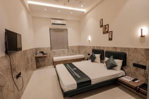 a bedroom with a bed and a flat screen tv at Hotel Gold Palace Inn in Surat