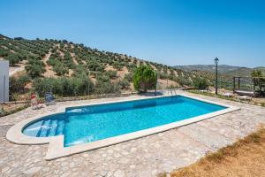 una piscina en un patio con una montaña en el fondo en El Ventorro, en Granada