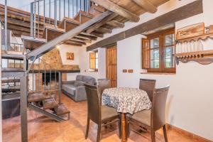 sala de estar con mesa y sillas y escalera en El Ventorro, en Granada
