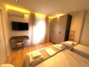 ein Hotelzimmer mit zwei Betten und einem Schreibtisch in der Unterkunft Luxurious & Spacious Old Bazaar Apartment in Tirana