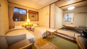 a hotel room with two beds and a window at Country Inn Canadian House in Myoko +170 photos