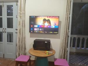 a flat screen tv on a wall in a room at Studio Apartment jungle view 2minutes drive to the beach in Colva +8 photos