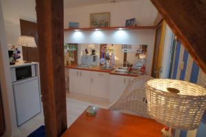 a kitchen with white cabinets and a sink and a table at Tante Hedwig in Świnoujście +9 photos