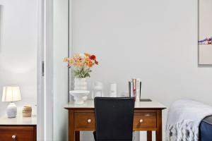 a bedroom with a desk with a vase of flowers on it at Cloud Nine City Centre 1BDR in Perth